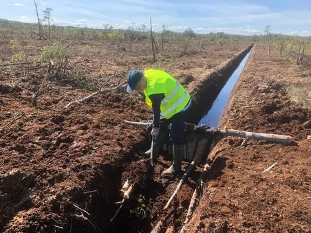 Aktivist gräver igen en dike på en torvbrytning i Sverige