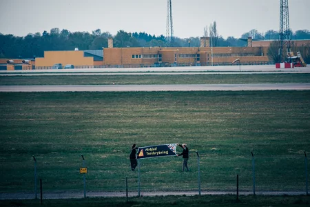 Två aktivister från Återställ Våtmarker på Malmö Airport med en stor banner som kräver ett förbjud av torvbrytning.