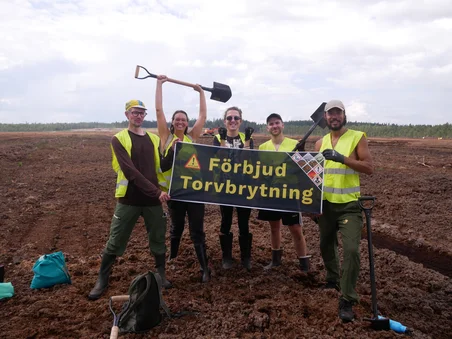 Group of activists at Grimsås mosse with a banner reading ‘Ban peat extraction’