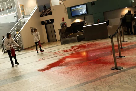 Aktivister från Återställ Våtmarker färgar golv röd i hallen av flygplats Landvetter
