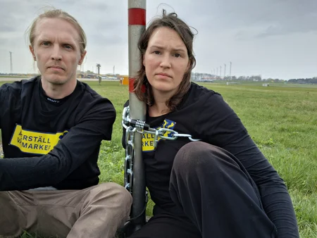 Aktivister från Återställ Våtmarker som låste sig på en stolpe på Malmö Airport.