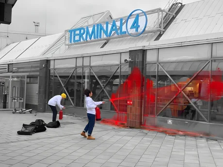 Aktivister som sprayar fönster av flygplatsterminalen Malmö med röd färg i protest mot miljöbrott på torvmosser