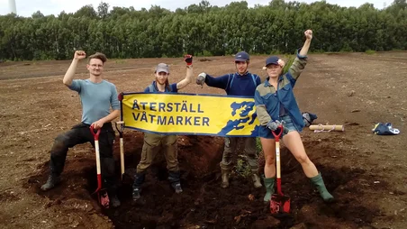 Unga människor på en torvbrott med en banner.