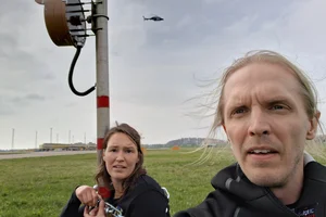 Två aktivister från Återställ Våtmarker på Malmö Airport. Hon i bakgrunden är låst på en stolpe via en kedja.