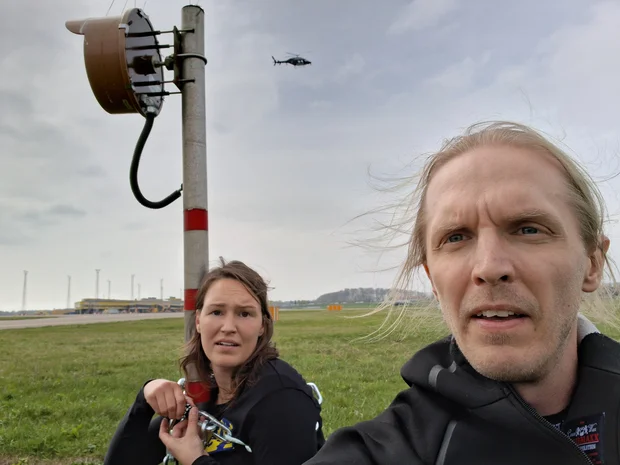 Två aktivister från Återställ Våtmarker på Malmö Airport. Hon i bakgrunden är låst på en stolpe via en kedja.