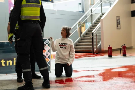 Knäande aktivist från Aktivister från Återställ Våtmarker mittemot säkerhetspersonal