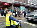 Människa med banner från Återställ Våtmarker som blockerar en väg i innerstaden i Stockholm