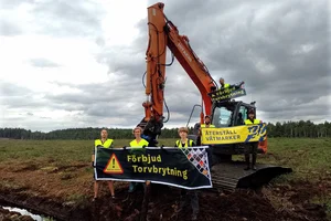 Flera människor som blockerar en baggare på en klimatskadlig torvbrott.
