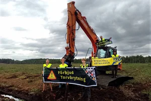 Flera människor som blockerar en baggare på en klimatskadlig torvbrott.