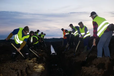 Group of people digging a ditch at Grimsås mosse