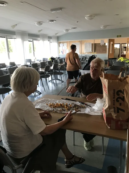Två personer som rensa kantareller för den gemensamma maten