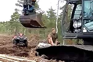 En aktivist som trycks ned på en grävmaskin av en Neova medarbetare