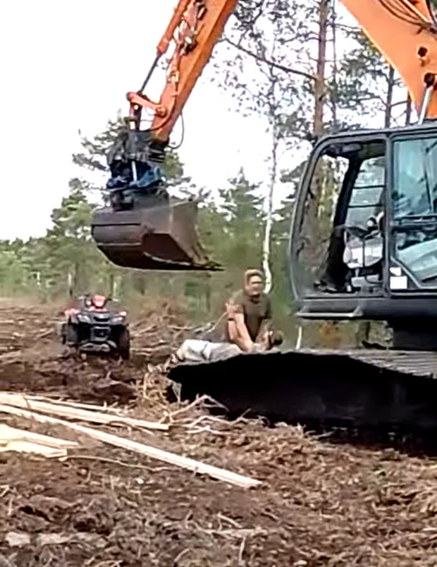 En aktivist som trycks ned på en grävmaskin av en Neova medarbetare