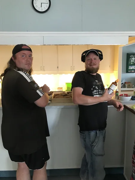 Två människor som står i kön för maten.