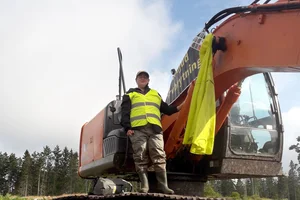 Aktivist från Återställ Våtmarker som ha limmat fast sig på en grävmaskin i protest mot torvbrottet