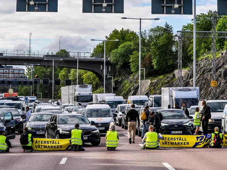Aktivister som blockerar alla fil av motorväg E4 med många biler i bakgrund