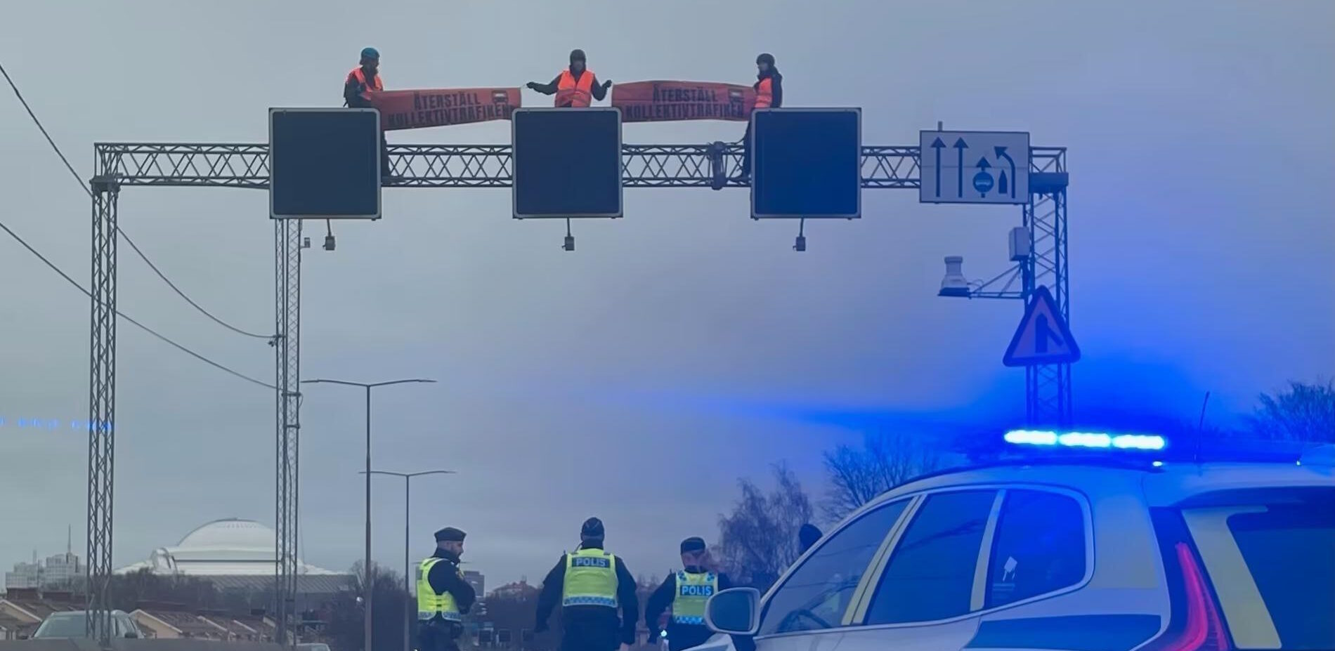 Aktivister klättrade upp på balk över motorvägen.